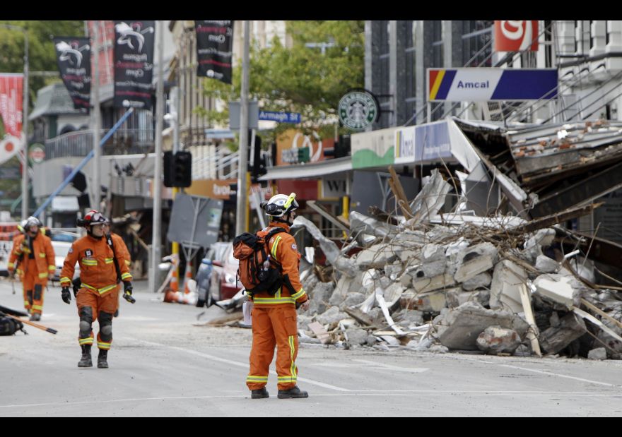 FILE - In this Feb. 26, 2011 file photo, representatives from the United Kingdom Fire and Rescue Service inspect the earthquake-damaged buildings in Colombo Street in Christchurch, New Zealand, following a magnitude 6.3 temblor. A powerful earthquake struck New Zealand on Monday, Nov. 14, 2016, reminding many of the quake that hit the nation in February 2011 and devastated the city of Christchurch, the country’s second-biggest city. (AP Photo/Mark Baker, File)