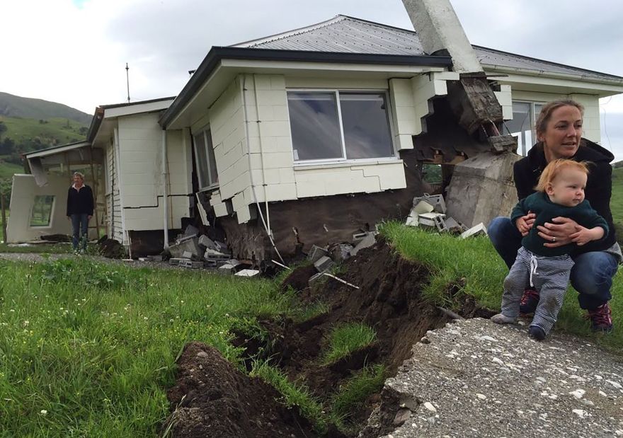 TOPSHOT - This photo taken and received on November 14, 2016 shows a woman and child in front of a house damaged by an earthquake as it sits on the fault line at Bluff Station near Kaikoura on the South Island's east coast. A powerful 7.8-magnitude earthquake killed two people and caused massive infrastructure damage in New Zealand, but officials said they were optimistic the death toll would not rise further. The jolt, one of the most powerful ever recorded in the quake-prone South Pacific nation, hit just after midnight near the South Island coastal town of Kaikoura. - - New Zealand OUT / RESTRICTED TO EDITORIAL USE MANDATORY CREDIT "AFP PHOTO / RADIO NEW ZEALAND / ALEX PERROTTET" NO MARKETING NO ADVERTISING CAMPAIGNS - DISTRIBUTED AS A SERVICE TO CLIENTS / AFP / RADIO NEW ZEALAND / ALEX PERROTTET / RESTRICTED TO EDITORIAL USE MANDATORY CREDIT "AFP PHOTO / RADIO NEW ZEALAND / ALEX PERROTTET" NO MARKETING NO ADVERTISING CAMPAIGNS - DISTRIBUTED AS A SERVICE TO CLIENTS